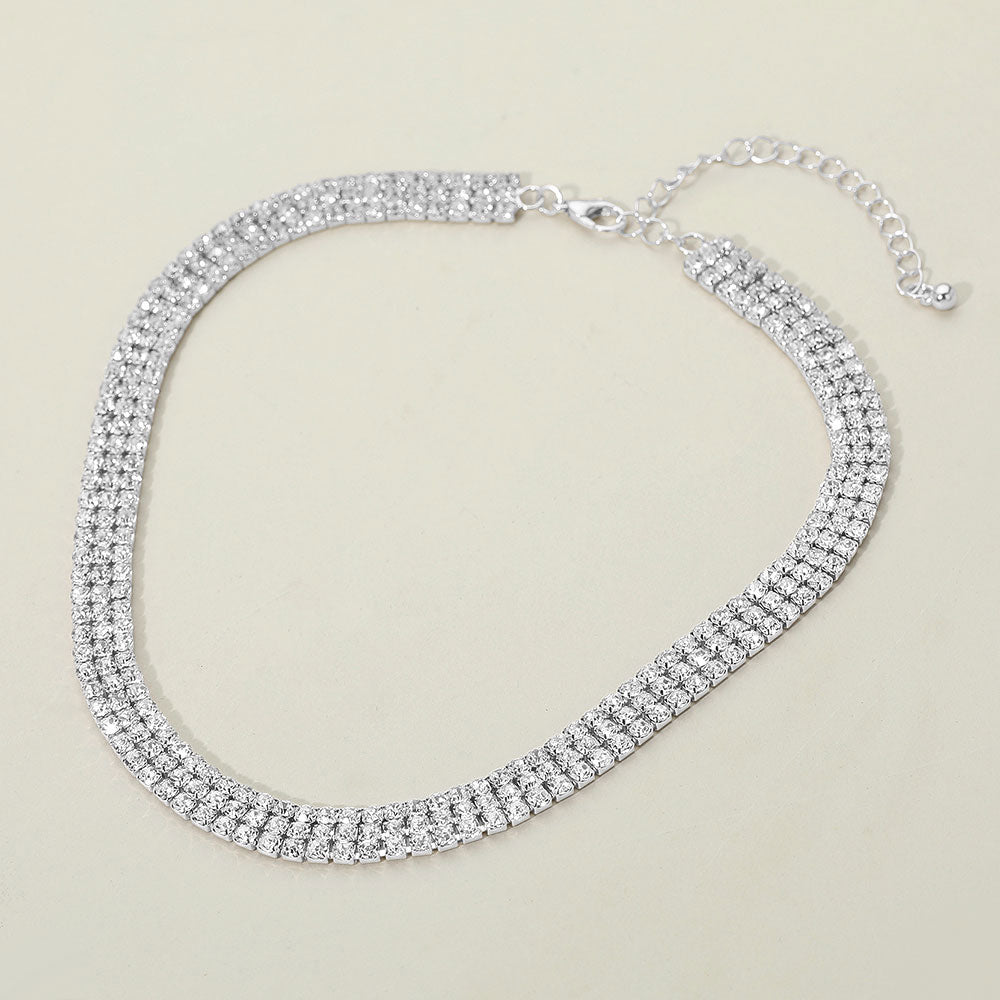 Silver triple strand rhinestone necklace with elegant crystal shine for weddings or formal events. Picture is on a white background.