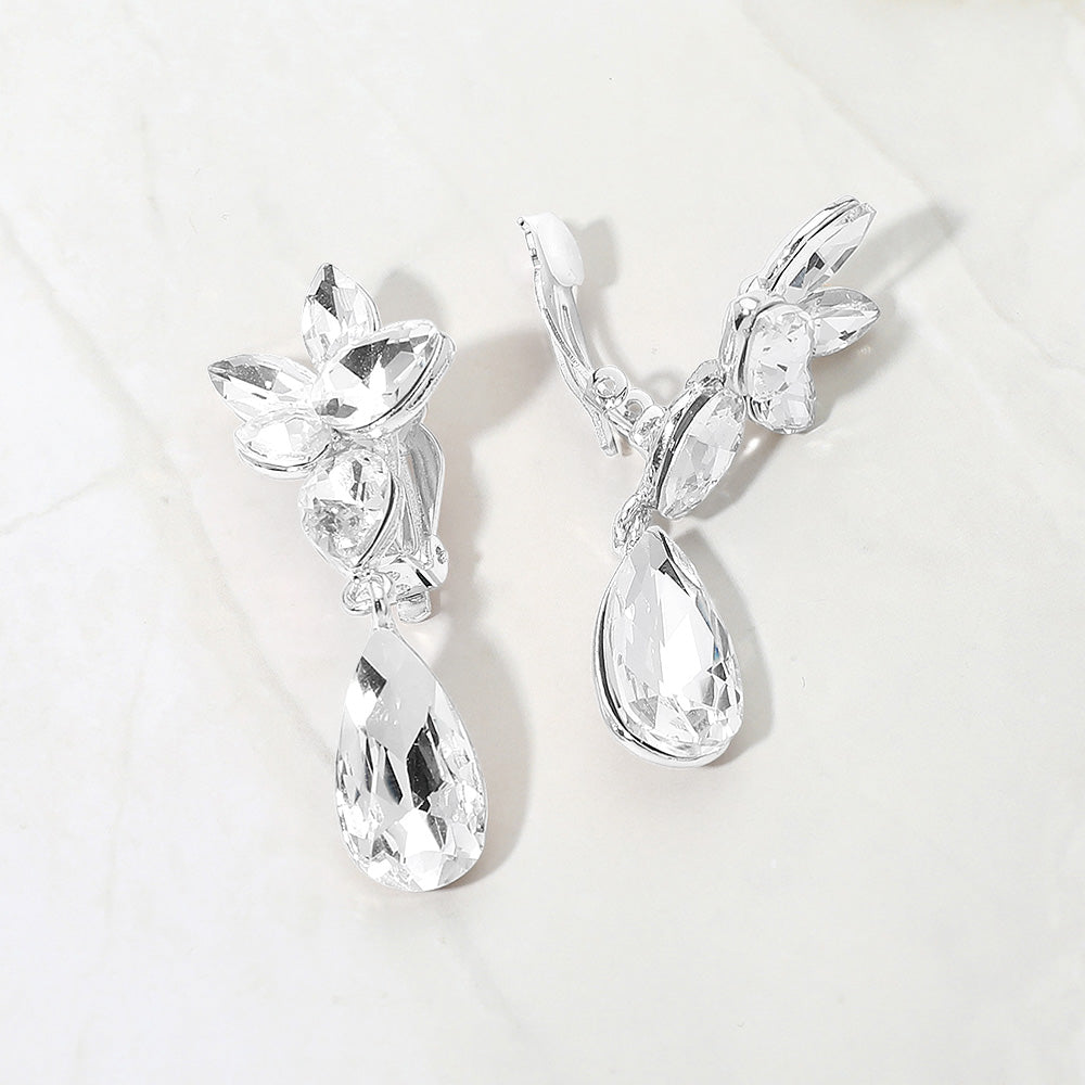 Slim clear crystal teardrop clip-on earrings on silver on white marble background