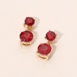 Small red double round little girls pageant drop earrings on gold on a beige background