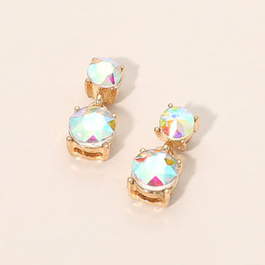 Small AB double round little girls pageant drop earrings on gold on a beige background