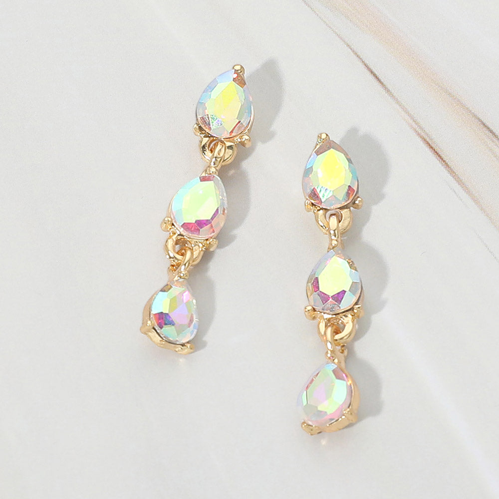 Small AB iridescent triple teardrop cluster drop earrings on gold on a white marble background
