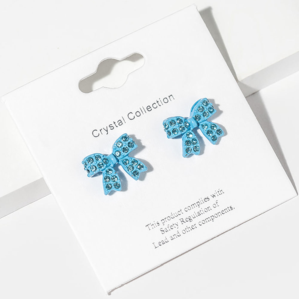 Aqua bow-shaped stud earrings on a Crystal Collection card with safety information-for little girls’ pageant or everyday wear.

