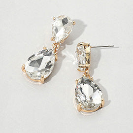 Pair of small teardrop-shaped earrings with clear gemstones set in gold on a light gray background