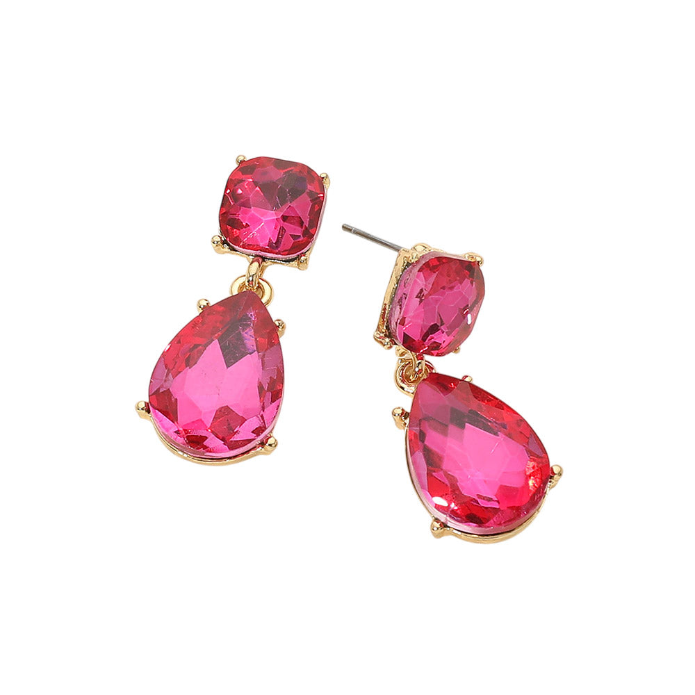 Fuchsia crystal drop earrings on gold with a cushion-cut top stone and large teardrop crystal, displayed on a light cream background.
