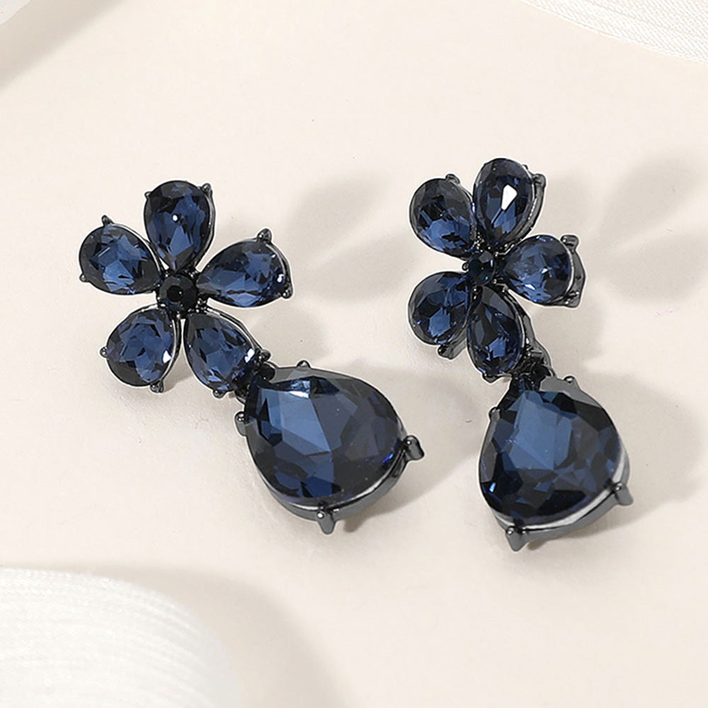 Navy blue flower and teardrop earrings with rhinestones for pageant or prom on a cream colored background