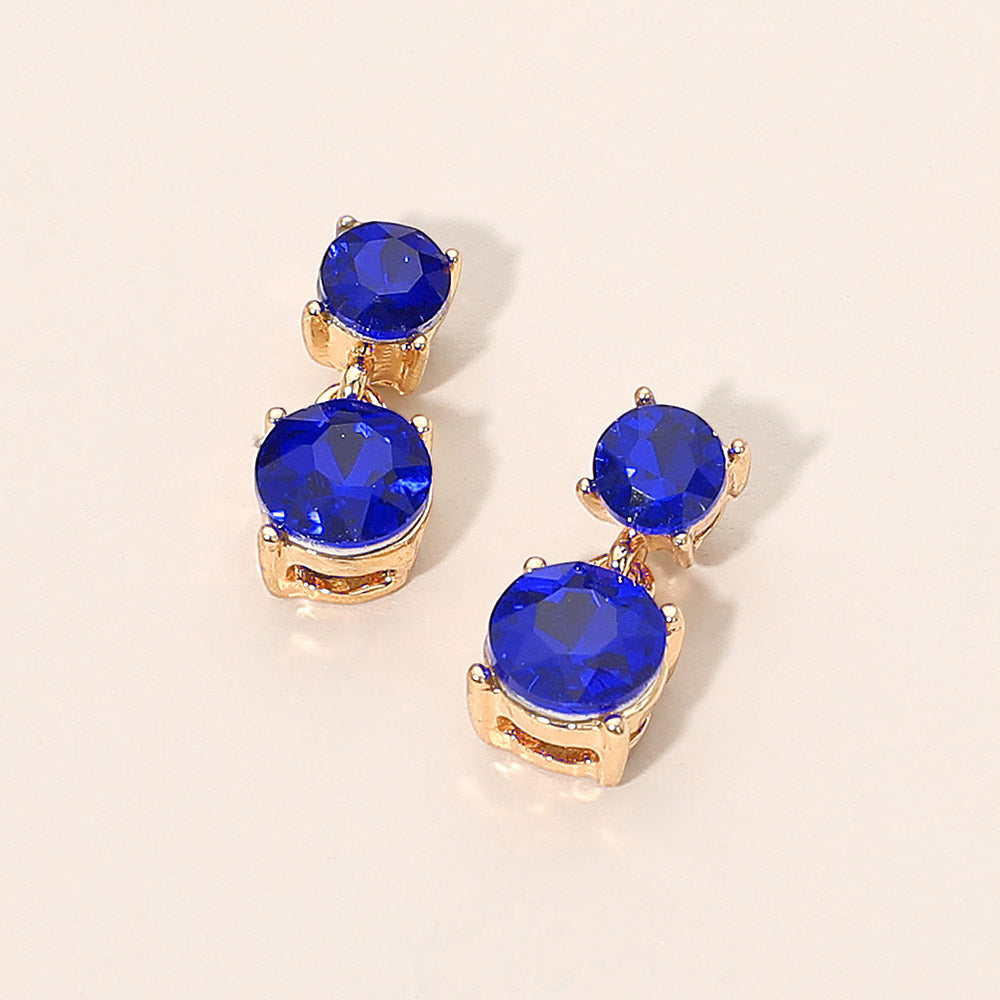 Small sapphire double round little girls pageant drop earrings on gold on a beige background