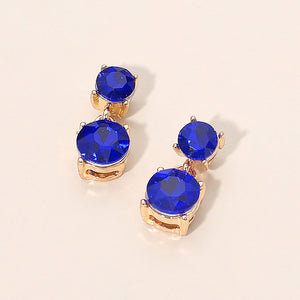 Small sapphire double round little girls pageant drop earrings on gold on a beige background