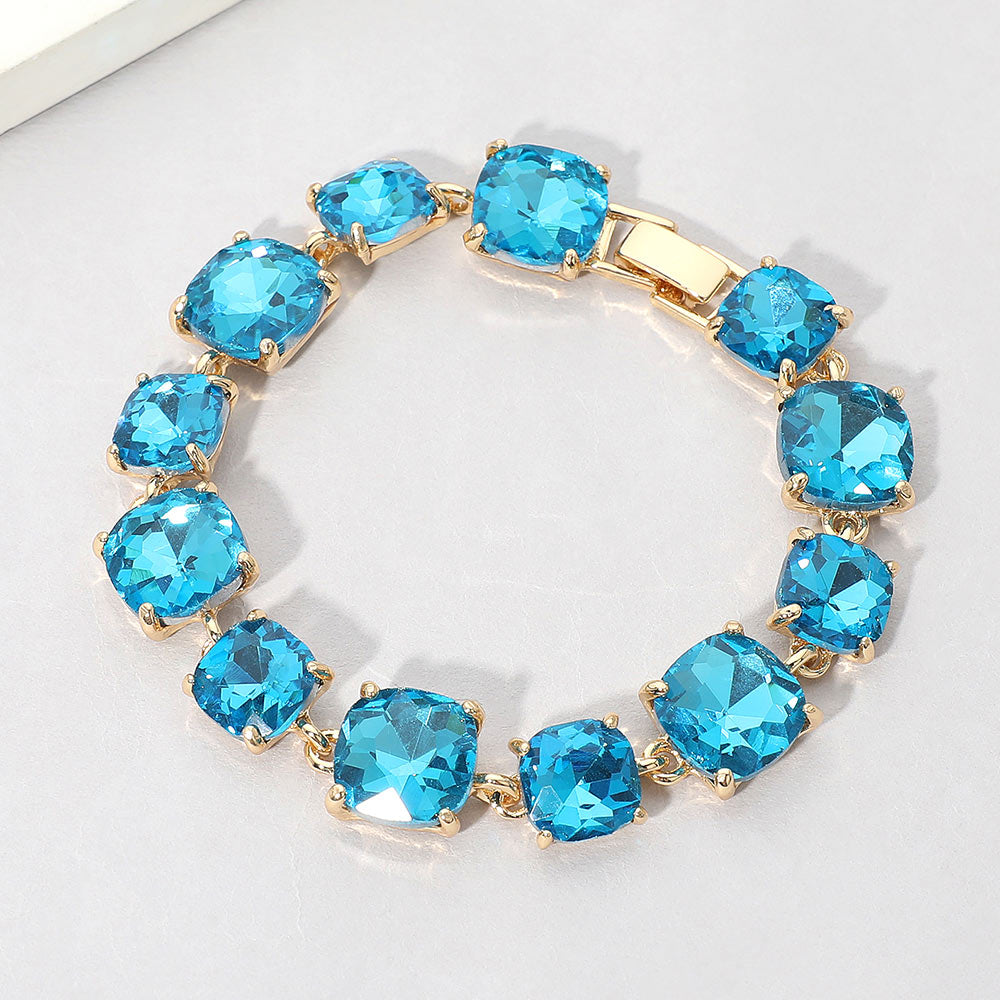 Teal cushion square crystal link bracelet on gold on white background