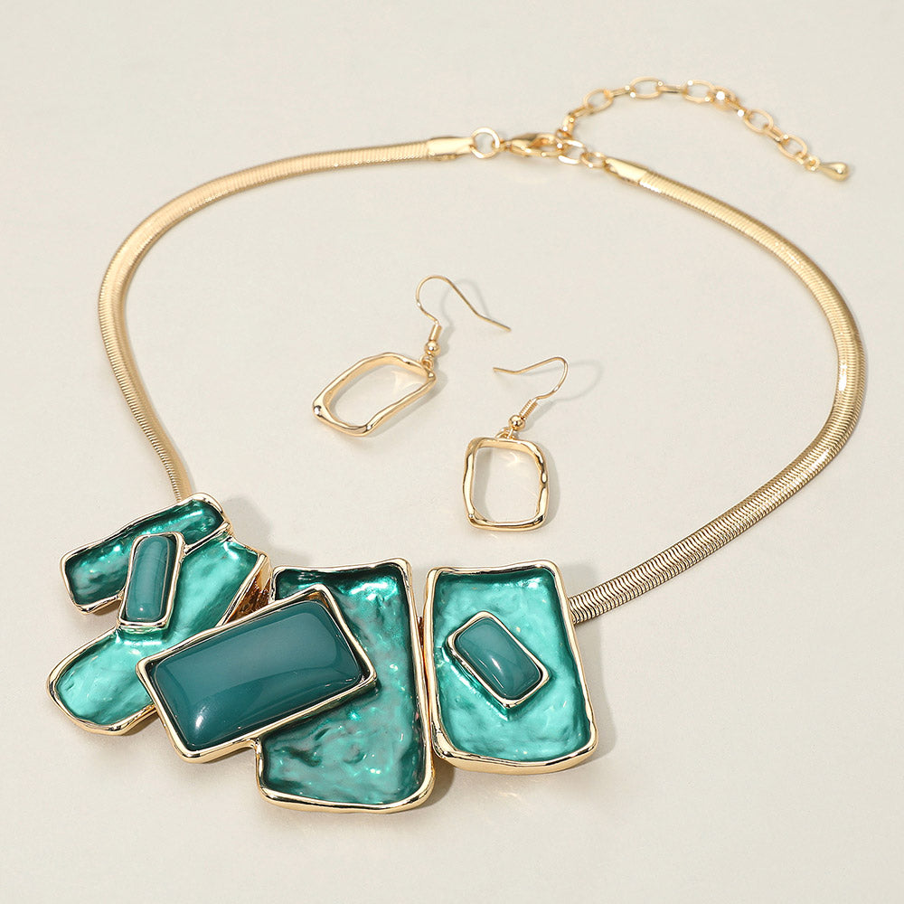 Teal geometric enamel beaded necklace set with matching earrings for pageant or prom style. It is on an ivory background.