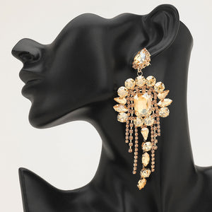 Long 4.6" topaz Gold Stone chandelier fringe earrings on a black mannequin ear — dramatic crystal statement jewelry for pageant, prom, weddings, and evening events.