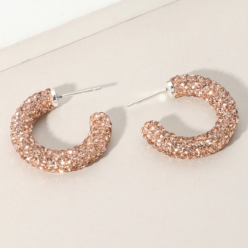 Champagne Gold Stone rhinestone pavé half hoop earrings in a silver finish featuring rows of champagne gold stones covering the front of each hoop, displayed on a light beige background.
