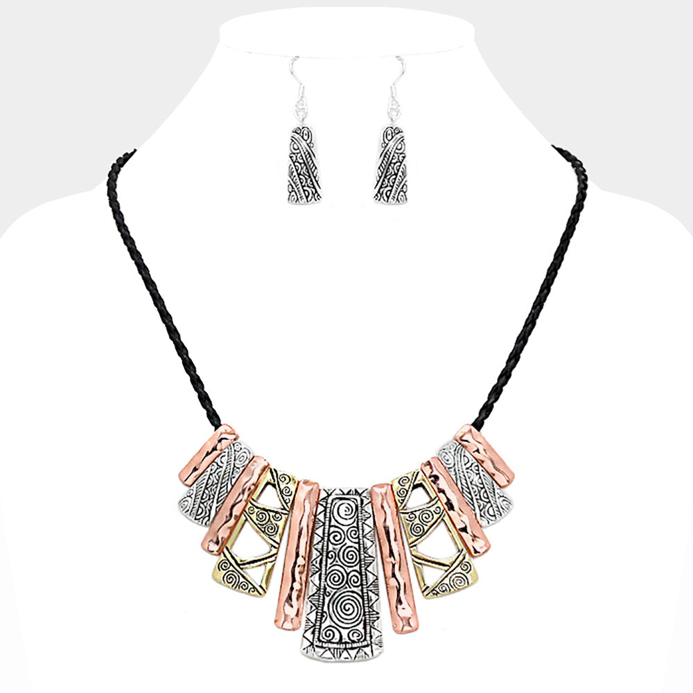 Unique Tribal pattern bar necklace set with shades of black, copper, gold and silver on a white mannequin bust