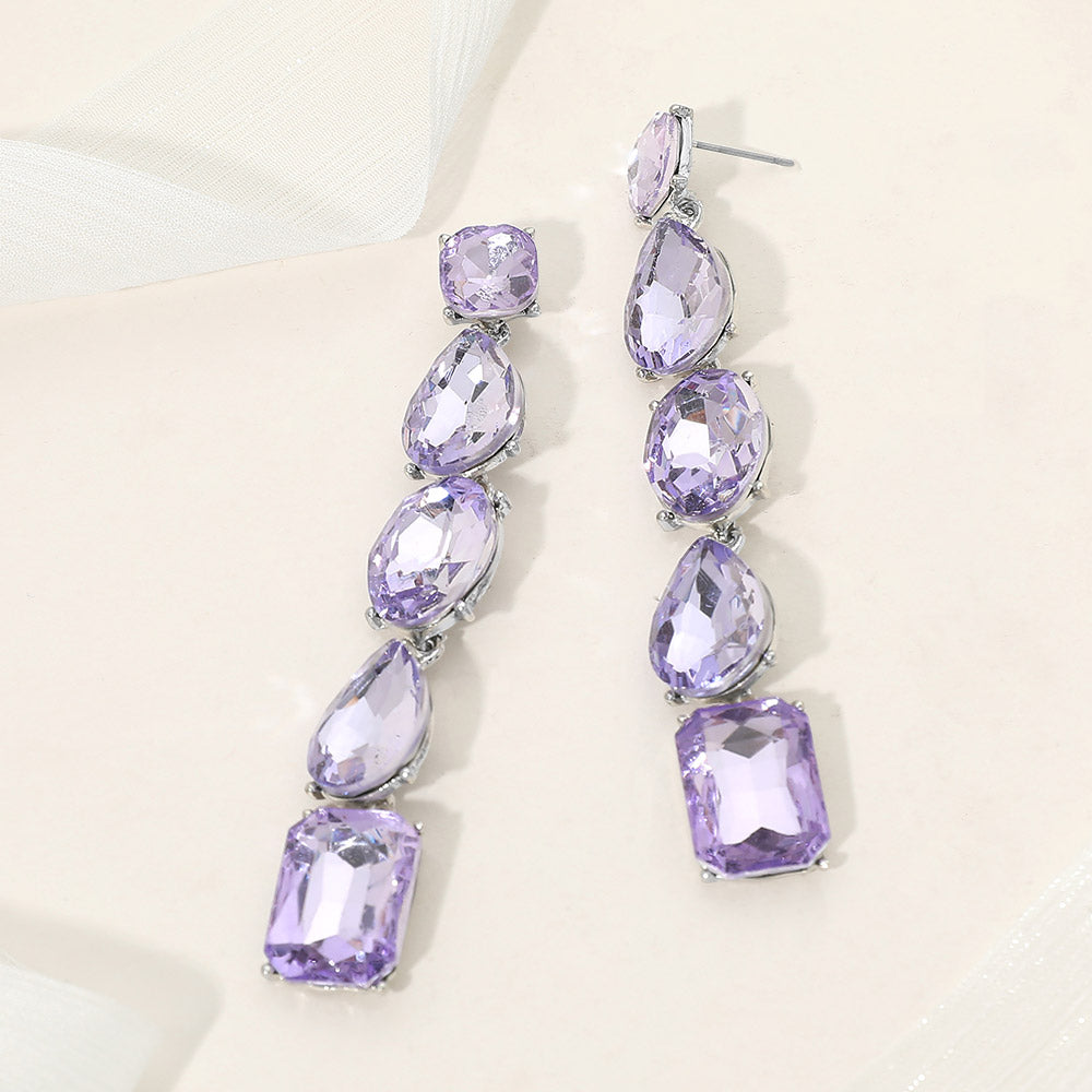 Violet purple faceted stone cluster prom pageant evening earrings in a silver setting on an off white background