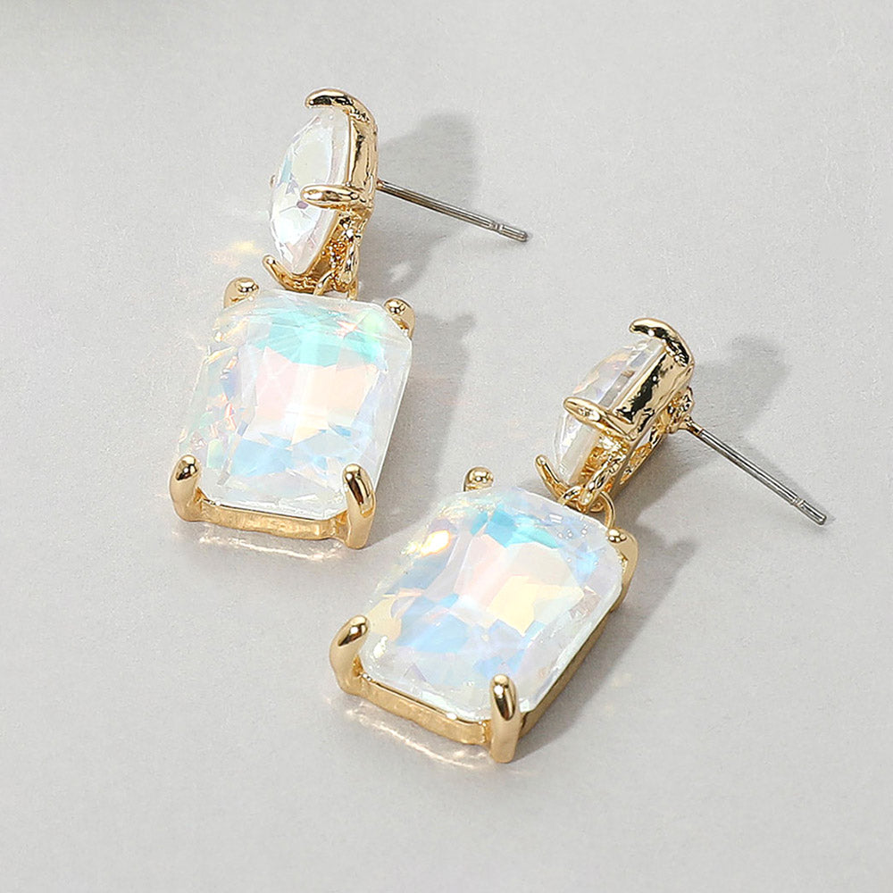 Gold-framed iridescent white opal earrings on a light gray background
