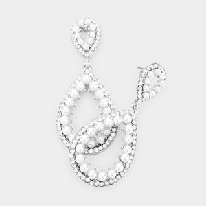 White pave pearl open teardrop earrings on silver displayed on white marble background