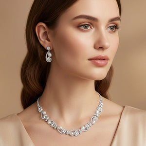 Model wearing white pearl and clear crystal bridal necklace set on silver with alternating pearl and crystal accents and matching drop earrings.