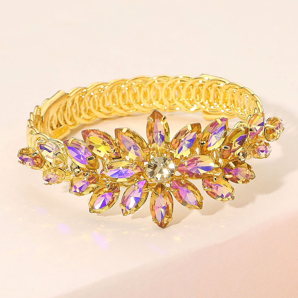 Yellow crystal floral marquise adjustable bracelet on gold displayed on a beige background.