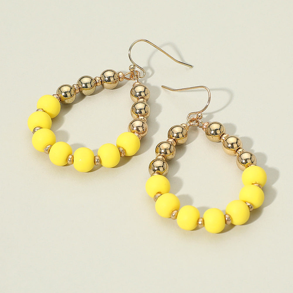 Yellow and gold ball teardrop statement earrings for pageants, runways, or prom looks on a white background