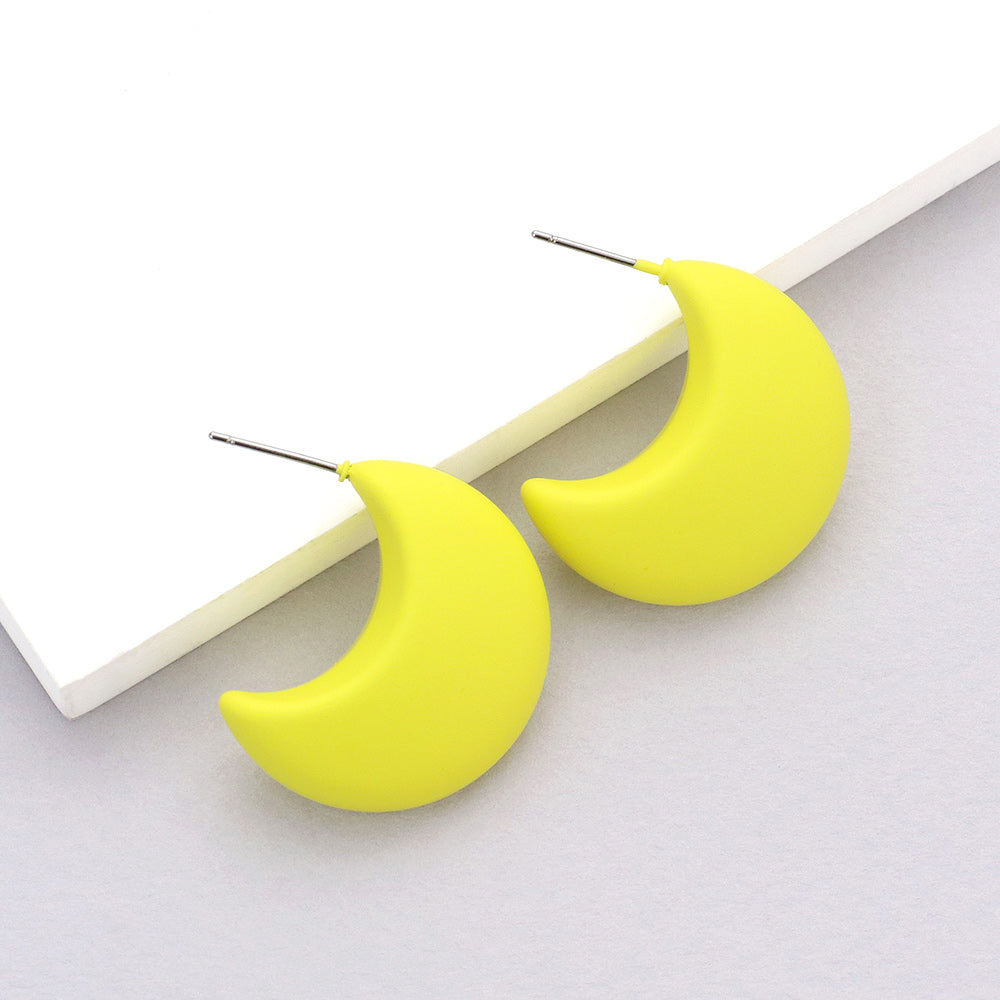 Yellow matte crescent moon earrings on a white background