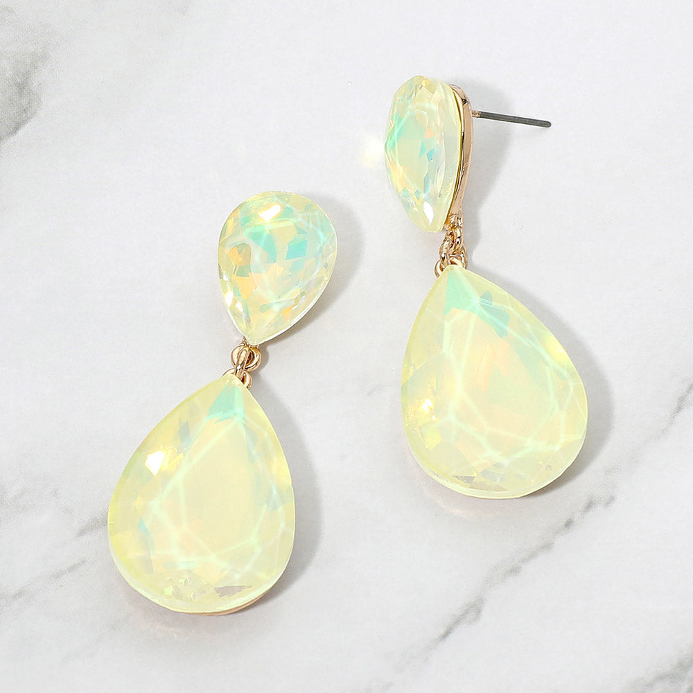 Yellow opal crystal double teardrop dangle earrings on gold displayed on a white marble background.