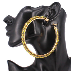 Oversized yellow baguette rhinestone hoop earrings on gold with omega back 3.5 inch diameter shown on a black mannequin ear