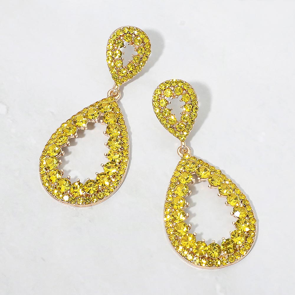 Yellow pave open teardrop earrings on gold displayed on white marble background