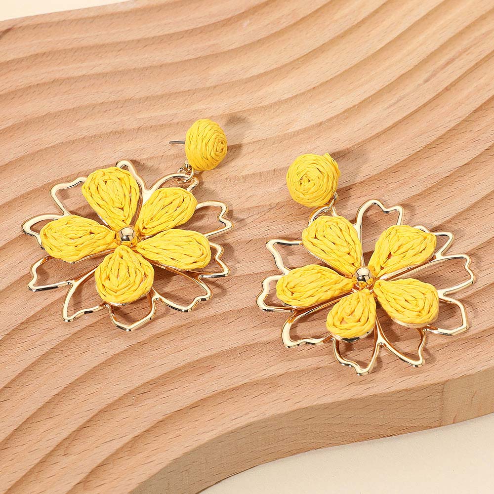 Yellow raffia floral petal dangle earrings with boho statement style for runway, pageant outfit of choice, or everyday fashion with wooden background