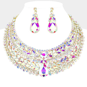 AB iridescent crystal statement necklace set on gold-tone metal, featuring a broad, layered bib of marquise and round stones with a large teardrop centerpiece and matching teardrop earrings reflecting rainbow colors. Necklace measures 17 inches plus a 2-inch extender, with 2.25-inch decor; earrings are 2.2 inches long. Displayed on a white jewelry bust against a white background.