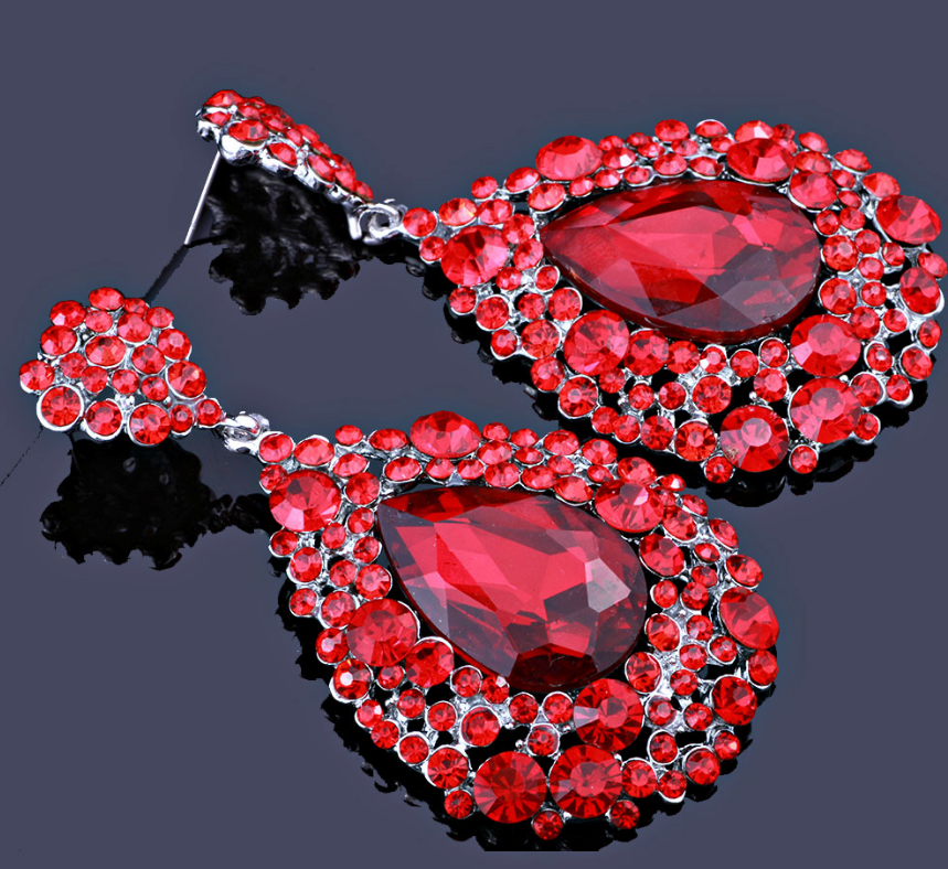 Chunky red teardrop earrings, NO AB stones, on a black background highlighting dramatic sparkle, layered stones, and bold statement design